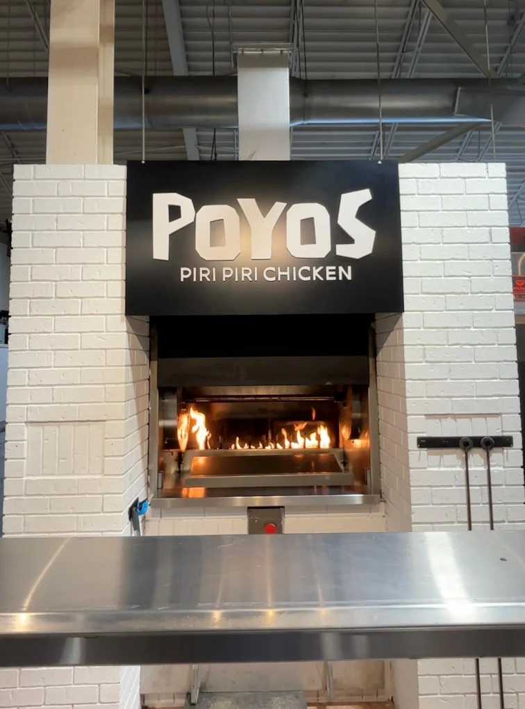 Flame-grilled piri piri chicken plated with onions and lime at Poyos Chicken London Ontario